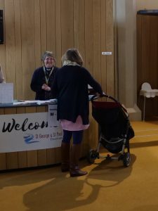 Woman with pushchair at welcome desk